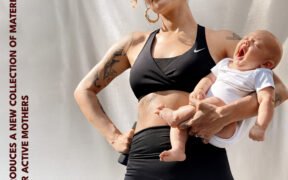 A Lady stands holding our son in black sports wear